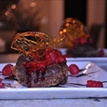 Collapsed Chocolate Souffle topped with raspberry sauce