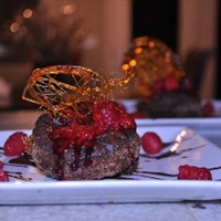 Collapsed Chocolate Souffle topped with raspberry sauce