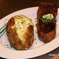 Steak with baked potatoes with cheese and butter